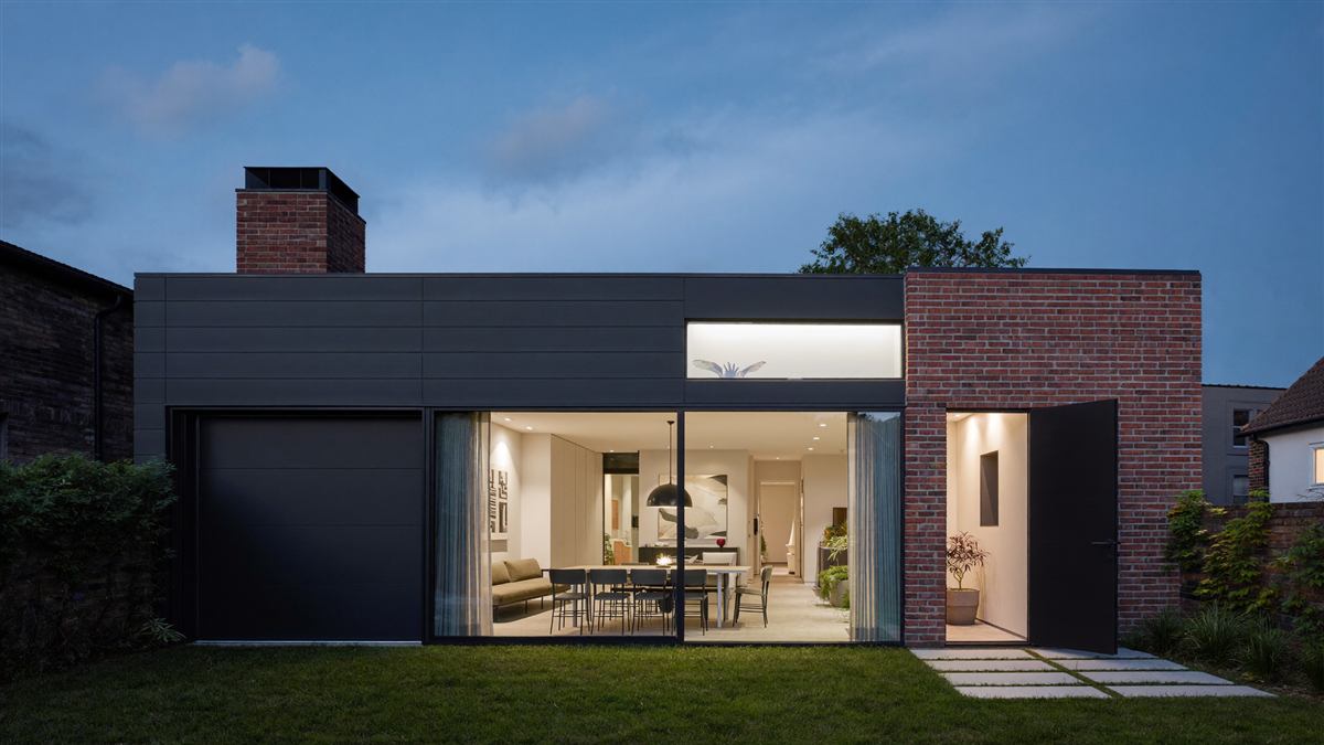 Modern glazed rear extension glowing at dusk
